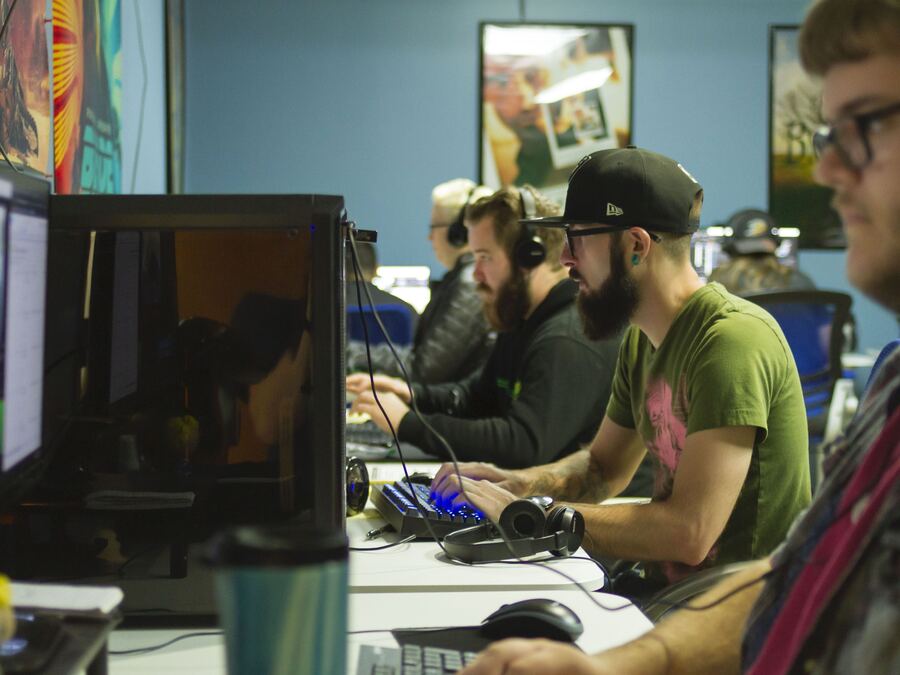 A team reviewing evaluation video at their workstations
